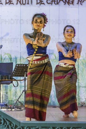Traditional Thai dancers perform on a lighted stage at the night market in downtown Chiang Rai, Thailand