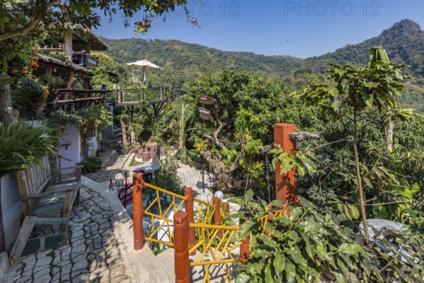 Swing and benches in the lush garden at the Doi Phamee coffee shop and restaurant in Mae Sai district of Chiang Rai, Thailand