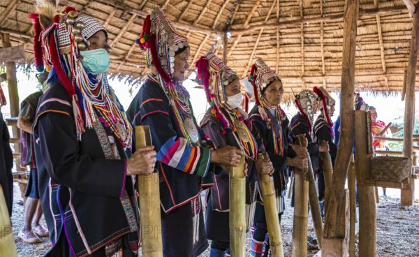 Elderly traditionally dressed people perform a musical chant for a fee in the Akha tribe area of the Union of Hill Tribe Villages outside of Chiang Rai in the Nanglae District of Thailand