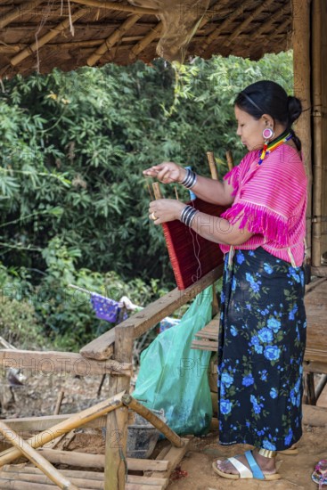 Woman weaving items to sell at the Union of Hill Tribe Villages outside of Chiang Rai in the Nanglae District of Thailand
