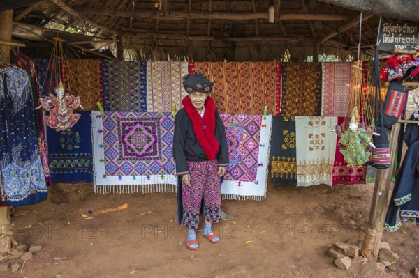 Traditionally dressed woman selling hand woven items in the Lu Mien-Yao tribe area of the Union of Hill Tribe Villages outside of Chiang Rai in the Nanglae District of Thailand