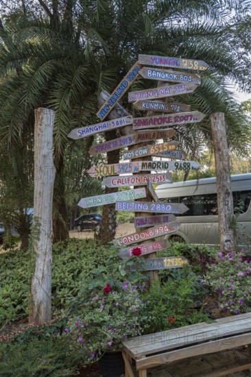 Sign post with arrows pointing to other places and showing the distance from Chiang Rai, Thailand