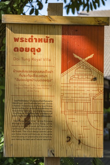 Wooden sign in Thai and English describes the Doi Tung Royal Villa inside the Doi Tung tourist attraction in Chiang Rai, Thailand