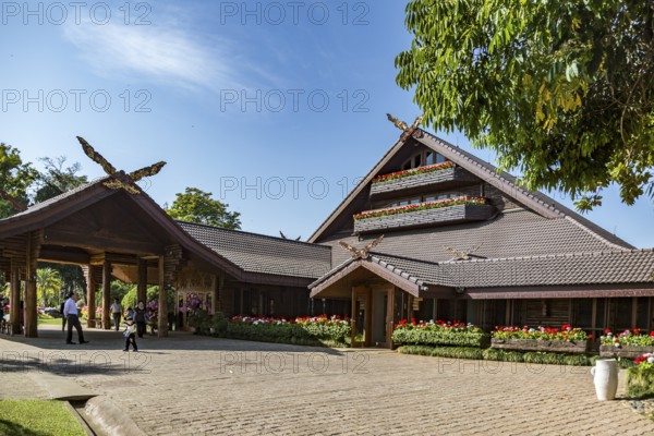 Ornate trees and lush flower gardens enhance the Lanna and Swiss architecture of the Doi Tung Royal Villa inside the Doi Tung tourist attraction in Chiang Rai, Thailand