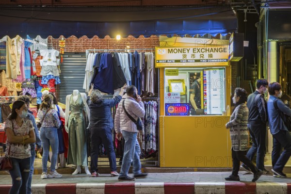 Money Exchange booth on sidewalk of busy downtown street in Chiang Rai, Thailand
