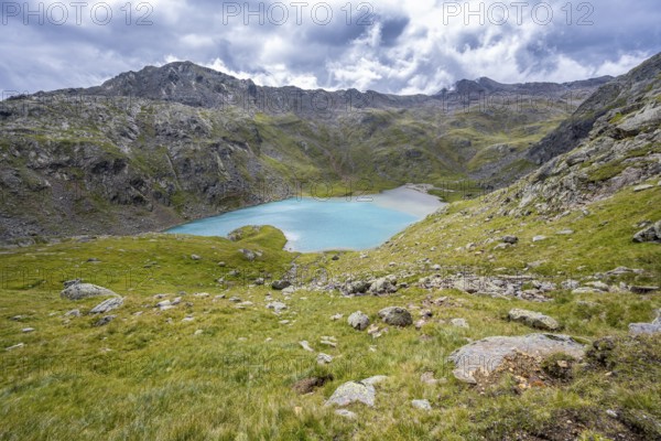 Light blue mountain lake Trüber See in a barren mountain landscape, seven-lake hike, Stubai Alps, near Ridnaun, South Tyrol, Italy