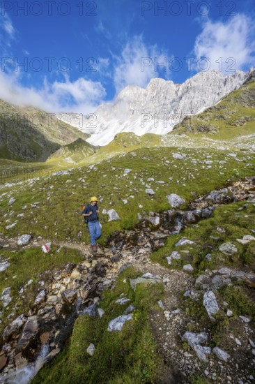 Mountaineers on a hiking trail, behind them rocky mountain peaks of the Moarer Weißen, Seven Lakes Hike, Stubai Alps, near Ridnaun, South Tyrol, Italy