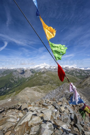 Böses Weibl summit with colourful prayer flags, view of picturesque mountain landscape with snow-covered summit of the Großglockner, Wiener Höhenweg, Schober group, Hohe Tauern National Park, Carinthia, Austria