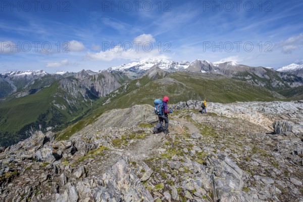 Mountaineers on a hiking trail, view of picturesque mountain landscape with snow-covered summit of the Großglockner, Vienna High Trail, Schober Group, Hohe Tauern National Park, Carinthia, Austria