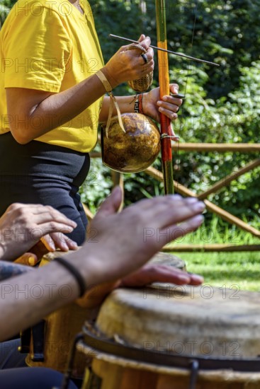 Group of people playing berimbau and atabaque in Brazilian capoeira outdoors, Minas Gerais, Brazil