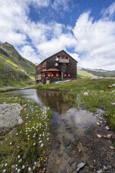 Elberfelderhütte mountain hut with small lake and cotton grass, in the upper Gössnitz valley, Vienna High Trail, Schober Group, Hohe Tauern National Park, Carinthia, Austria