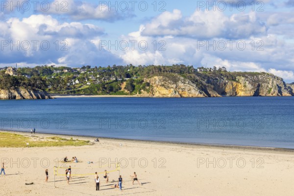Young people playing beach volleyball on a sand beach a sunny summer day by the sea, Crozon peninsula, Bretagne, France