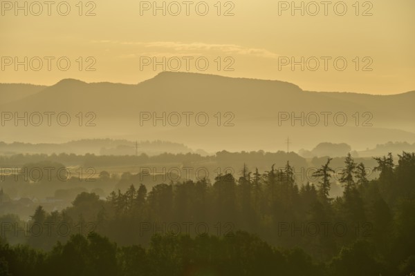 Gentle misty landscape with trees and mountains in the morning light, Germerode, Geo nature park Park Frau-Holle-Land, Hoher Meissner, Hesse, Germany
