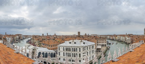 Stunning panoramic cityscape of venice, italy, showcasing the grand canal, traditional terracotta rooftops, and historic landmarks under a cloudy sky