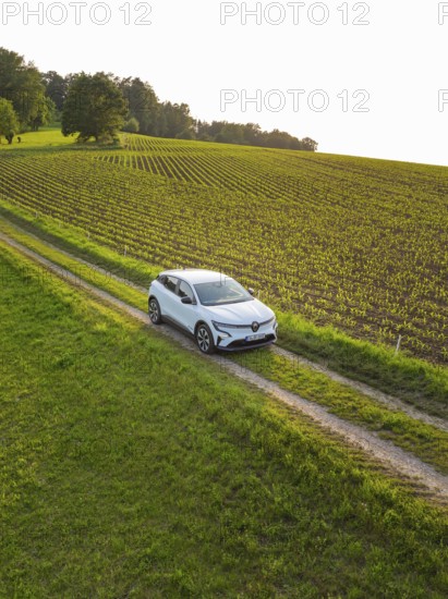 Small car drives on a green country road through a quiet village idyll, Renault Megane, Deer E Carsharing, electric car, Calw, Black Forest, Germany