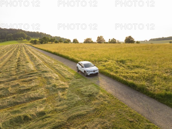 Car driving on a country road through a varied landscape at sunset, Renault Megane, Deer E Carsharing, electric car, Calw, Black Forest, Germany