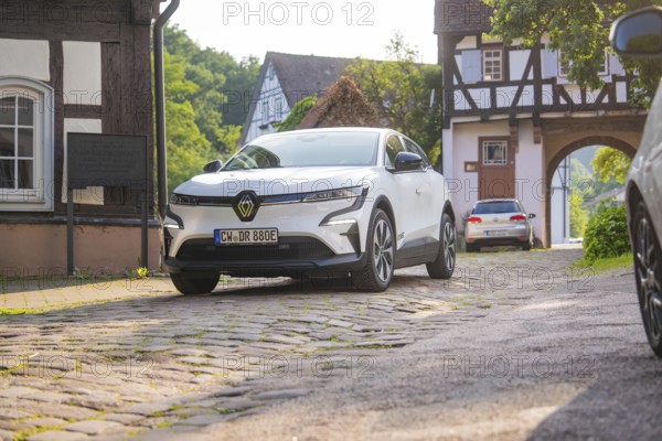 White car on a cobbled street in a picturesque village with half-timbered houses, Renault Megane, Deer E Carsharing, electric car, Calw, Black Forest, Germany