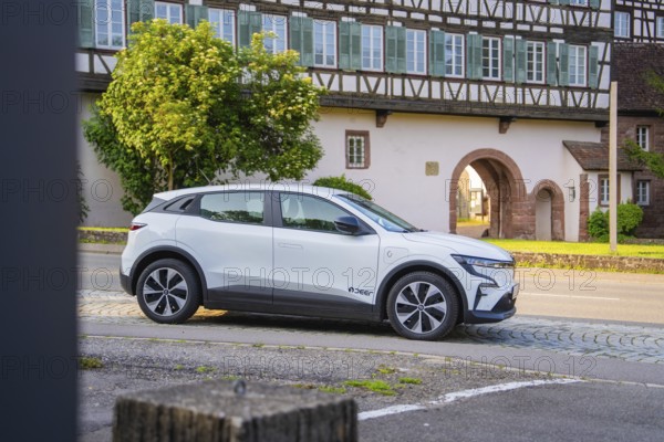 White car in front of a row of traditional half-timbered houses, surrounded by greenery in summer, Renault Megane, Deer E Carsharing, electric car, Calw, Black Forest, Germany