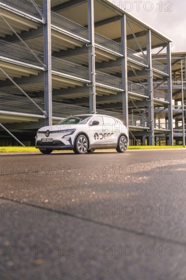 White Renault car in front of a multi-storey car park from a low perspective, Renault Megane, Deer E Carsharing, electric car, Calw, Black Forest, Germany