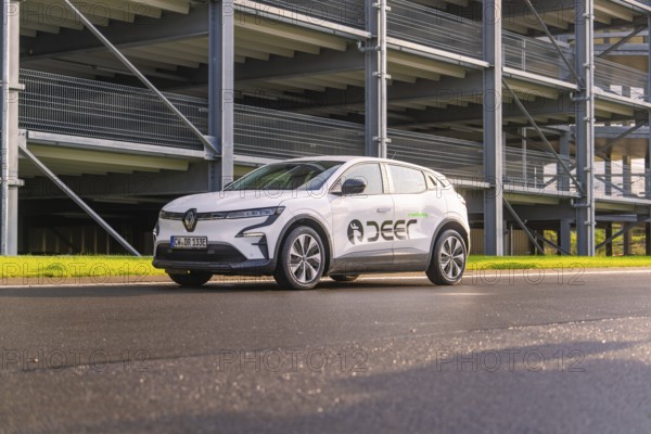 Renault car on an asphalt road in front of a multi-storey car park, Renault Megane, Deer E Carsharing, electric car, Calw, Black Forest, Germany