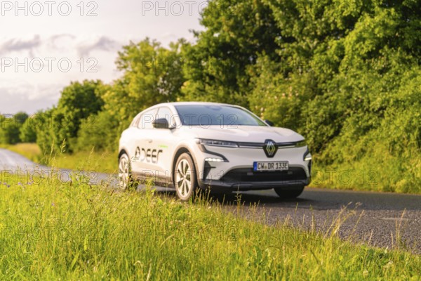 Renault car drives along a green, tree-lined country road, Renault Megane, Deer E Carsharing, electric car, Calw, Black Forest, Germany