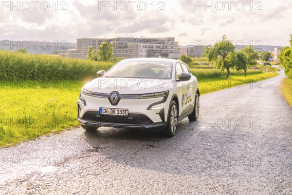 White Renault driving on a country road with the urban background, Renault Megane, Deer E Carsharing, electric car, Calw, Black Forest, Germany