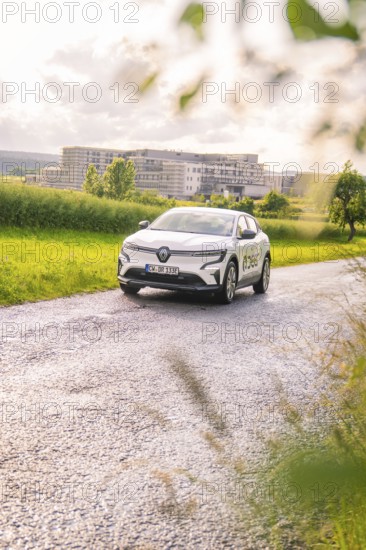 White Renault car on a rural road, surrounded by fields and trees, Renault Megane, Deer E Carsharing, electric car, Calw, Black Forest, Germany