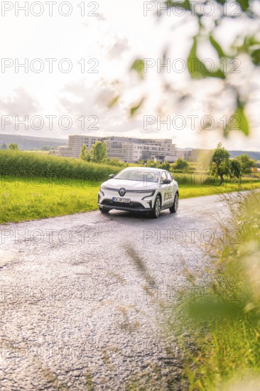 Renault car on a lonely road with trees and buildings in the background, Renault Megane, Deer E Carsharing, electric car, Calw, Black Forest, Germany