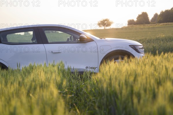White car in profile, surrounded by green field in late daylight, Renault Megane, Deer E- Carsharing, electric car, Gechingen, Germany