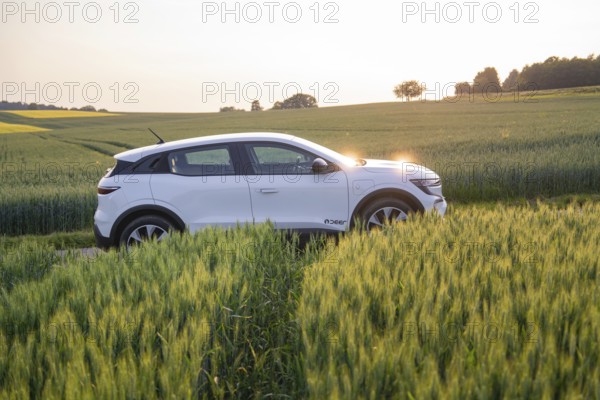 White electric car drives through a green field at sunset, Renault Megane, Deer E- Carsharing, electric car, Gechingen, Germany