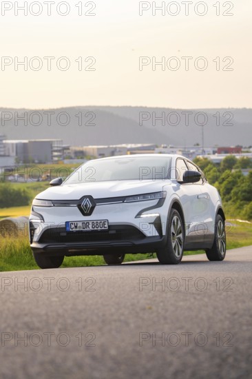 Car driving along a road with a view of modern buildings in the background, Renault Megane, Deer E- Carsharing, electric car, Gechingen, Germany