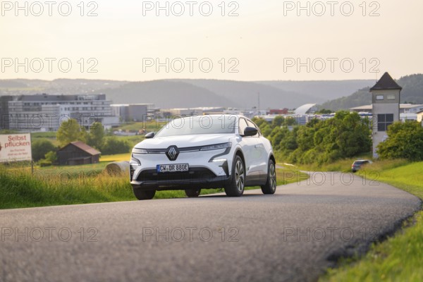 Car driving on a curvy road with modern city view in the background, Renault Megane, Deer E- Carsharing, electric car, Gechingen, Germany