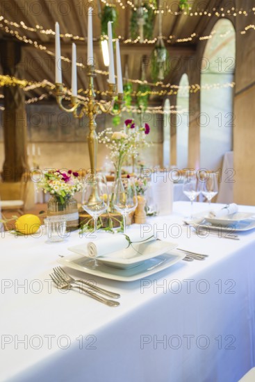 Elegant table decorations with flowers and candlesticks, white tablecloths create a festive atmosphere, event and wedding location Lorch Monastery, Lorch, Germany