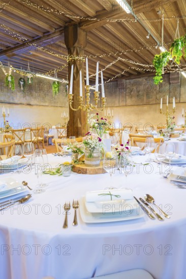 Round table beautifully set with flowers and candlesticks, surrounded by elegant fairy lights decoration, event and wedding location Lorch Monastery, Lorch, Germany