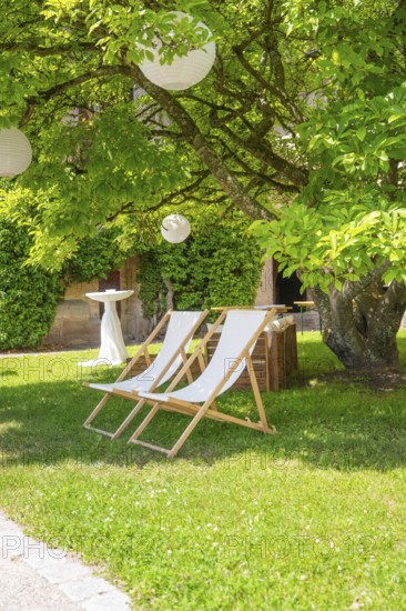 Two deckchairs in the shade of a tree on a green meadow, ideal for relaxation, event and wedding location Lorch Monastery, Lorch, Germany
