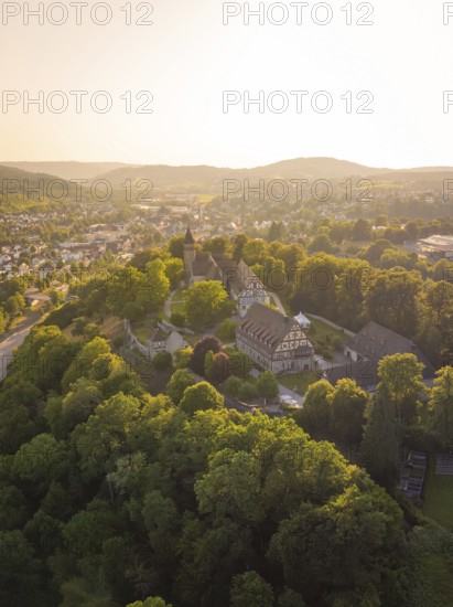 Aerial view of a historic castle surrounded by wooded hills at sunset, event and wedding location Lorch Monastery, Lorch, Germany