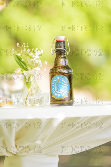 Table with a beer bottle and flower vase outside on a sunny day, event and wedding location Kloster Lorch, Lorch, Germany