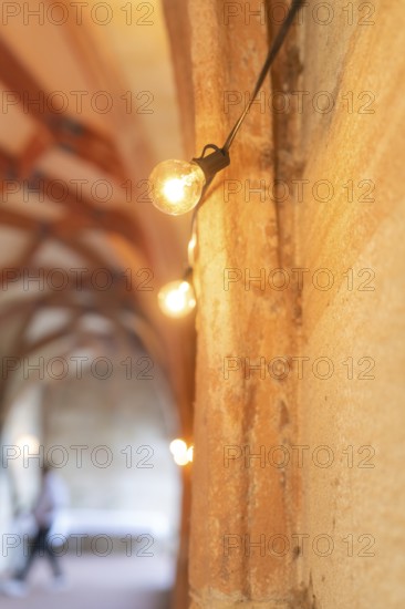 Warm light from fairy lights in a historic stone archway, event and wedding location Lorch Monastery, Lorch, Germany