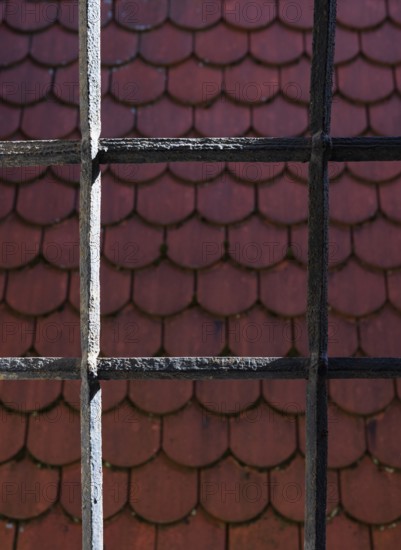 View through bars onto a red shingle roof, house roof, detail, Steyr, Upper Austria, Austria