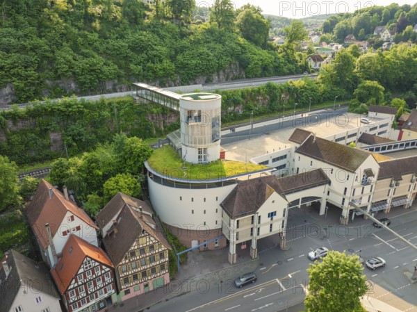 Modern building with green space, surrounded by half-timbered houses and hills, Calw, Black Forest, Germany
