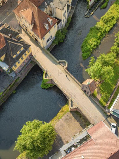 River with stone bridge and neighbouring historic buildings from the air, Calw, Black Forest, Germany