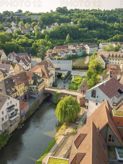 Old town with half-timbered houses along a river, surrounded by green hills, Calw, Black Forest, Germany