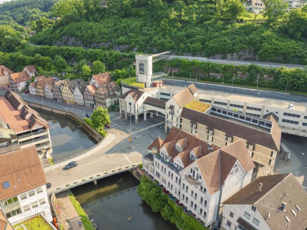 Mixture of modern and historic buildings on a river, surrounded by greenery, Calw, Black Forest, Germany