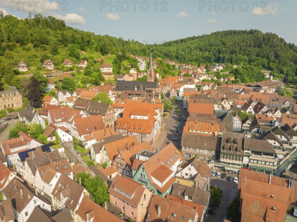 Historic town with red roofs and a church surrounded by green hills, Calw, Black Forest, Germany