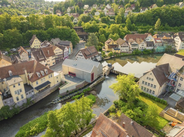 Idyllic town with river in front of a wooded hill with half-timbered architecture, Calw, Black Forest, Germany