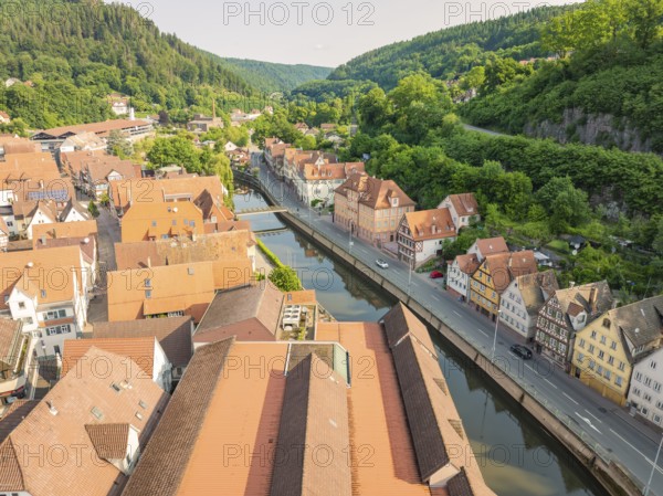 Town with red roofs on a winding river, embedded in forest hills, Calw, Black Forest, Germany