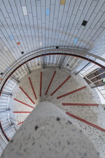 A spiral staircase with colourful tiles and a central concrete pillar, modern architectural design, historical art exhibition in the old swimming pool, show depot, Calw, Black Forest, Germany