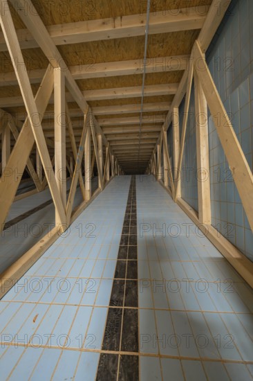 View into an attic with wooden struts and blue tiled floor leading into the distance, historical art exhibition in the old swimming pool, show depot, Calw, Black Forest, Germany