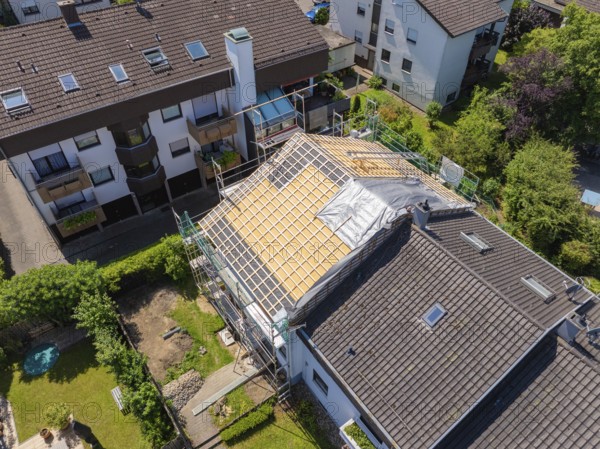 Several houses in the neighbourhood. A roof is under construction with scaffolding, sunny weather, roof renovation, house construction, Pforzheim, Germany