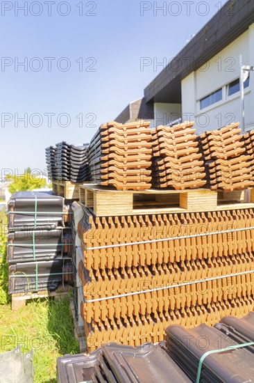 Stack of roof tiles on pallets next to a building outdoors, roof renovation, house construction, Pforzheim, Germany